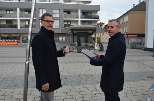 Erster Bürgermeister Daniel Güthler (links) und Johannes Rager von den Stadtwerken testen mit Handy und Tablet das neue öffentliche W-Lan-Netz am Holzgrundplatz. Foto: Peter Meuer