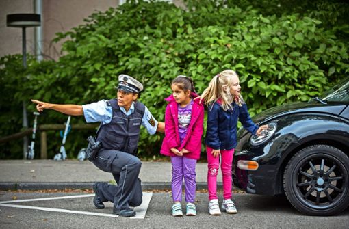 Rwaida Ali Mirze und Emilia Schwarz (re.) üben in Degerloch mit einer Polizistin, wie man sicher eine Straße überquert.. Foto: Lichtgut/Leif Piechowski
