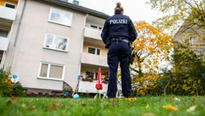 Eine Polizistin steht im Garten des Mehrfamilienhauses, wo eine 15-Jährige ihren dreijährigen Halbbruder getötet haben soll Foto: dpa/Guido Kirchner