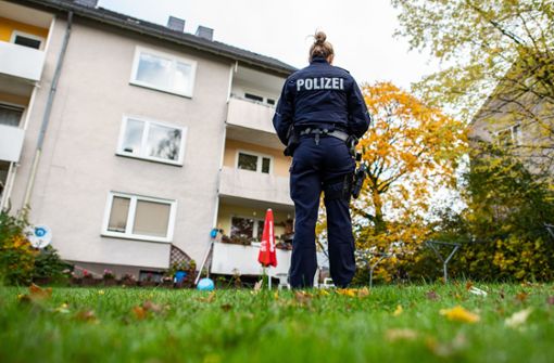 Eine Polizistin steht im Garten des Mehrfamilienhauses, wo eine 15-Jährige ihren dreijährigen Halbbruder getötet haben soll Foto: dpa/Guido Kirchner