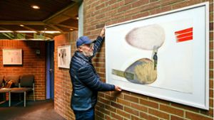 Uli Riederer vom Kulturforum Rutesheim rückt die Bilder ins rechte Licht. Foto: Simon Granville