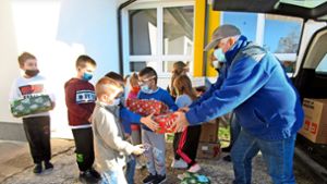 Mit weihnachtlich verpackten Kartons voller Geschenke werden bosnische Kinder von den Helfern bedacht. Foto:  
