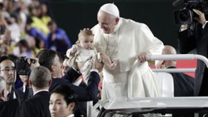 Papst Franziskus war zu Besuch in Japan, auf dem Weg zur Messe streichelte er Kindern über den Kopf, die zu ihm gehalten wurden. Foto: dpa/Gregorio Borgia