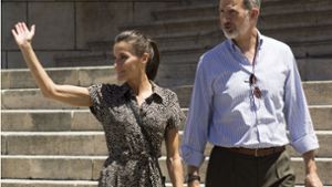 Felipe VI., König von Spanien, und seine Frau Letizia winken Anhängern zu. Das Königspaar reist zurzeit durch Spanien mit dem Ziel, die wirtschaftliche Erholung zu fördern. Foto: dpa/Rubén Marco Checa