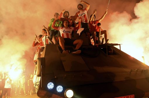 Spieler und Fans fahren auf einem Panzer durch Belgrad. Foto: AP