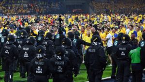 Die Beamten schützen nach dem Platzsturm den Fanblock des VfL Wolfsburg. Foto: Bongarts