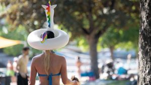 Im Inselbad in Untertürkheim hat sich eine Frau einen Einhorn-Schwimmreif auf den Kopf gesetzt. Foto: dpa/Sebastian Gollnow