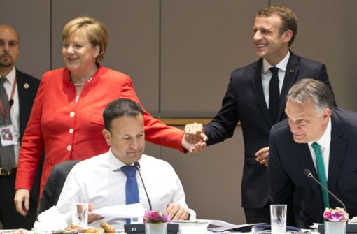 Kanzlerin Angela Merkel und Frankreichs Staatschef Emmanuel Macron Hand in Hand – die EU hat sich unter dem Eindruck der deutschen Regierungskrise auf eine Verschärfung ihrer Asylpolitik geeinigt. Foto: AP