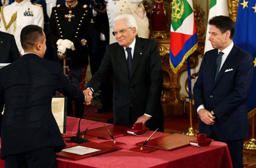 Italiens Außenminister Luigi Di Maio (links) schüttelt Präsident Sergio Mattarella (mitte) die Hand, während Ministerpräsident Giuseppe Conte  bei der Unterzeichnung des Amtseids zusieht. Foto: AFP