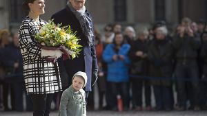 Neugierig linst die kleine Prinzessin Estelle an den Beinen ihrer Eltern Victoria und Daniel von Schweden vorbei. Foto: dpa