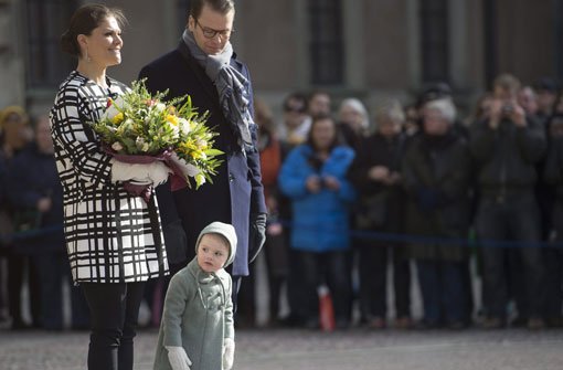 Neugierig linst die kleine Prinzessin Estelle an den Beinen ihrer Eltern Victoria und Daniel von Schweden vorbei. Foto: dpa