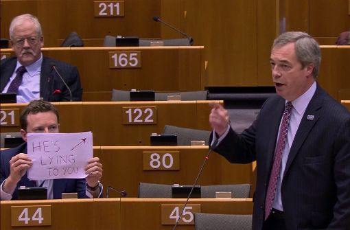 Seb Dance protestiert gegen Nigel Farage nur mit einem Papierschild. Foto: ap