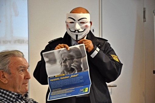 Der Präventionsbeamte Werner Mast veranschaulicht per Maske: Trickbetrüger zeigen  nicht ihr wahres Gesicht. Foto: Georg Linsenmann
