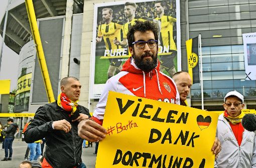 Ein Monaco-Fan bedankt sich bei den Dortmundern für die spontane Gastfreundschaft, die nach der Verlegung des Spiels eingesetzt hatte (links und rechts unten). Foto: AP, dpa (2)
