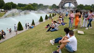 Touristen und Einheimische sitzen  am Brunnen im Jardin du Trocadéro in Paris. Foto: dpa