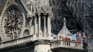 Experten besichtigen den Schaden nach dem Kirchenbrand. Foto: AFP