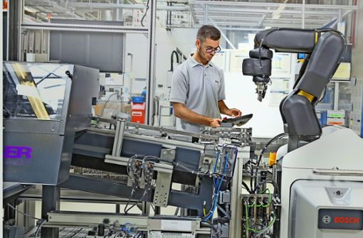 Mensch und Maschine arbeiten in der digitalen Fertigung Hand in Hand. Foto: Bosch