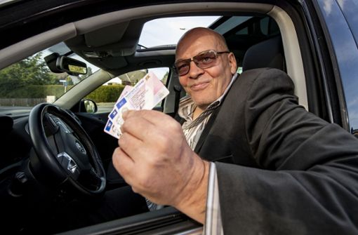 Rolf Herbrechtsmeier sitzt in seinem Auto und zeigt EU-Führerscheine. Nach seiner Meinung ist er nur ein Dienstleister für Verkehrssünder in Deutschland. Foto: dpa/David Inderlied