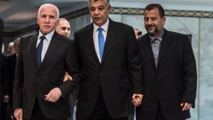 Durch Khaled Fawzi, Chef des ägyptischen Geheimdienstes, als Vermittler reichen sich die Fatah, vertreten durch Azzam al-Ahmad (links) und Hamas, durch Saleh al-Aruri (rechts), die Hand. Foto: AFP