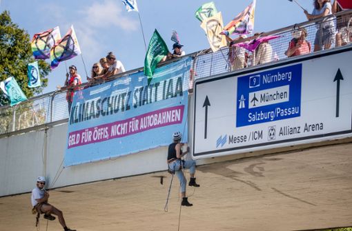 Klimaaktivisten der Extinction Rebellion München seilen sich über dem Georg-Brauchle-Weg über der Fahrbahn ab. Foto: dpa/Christoph Schmidt