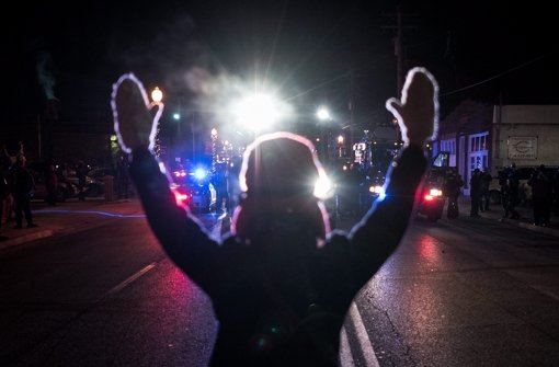 Ein Demonstrant blockiert eine Straße in Ferguson im US-Bundesstaat Missouri  nachdem bekannt wurde, dass keine Anklage gegen den Todesschützen von Michael Brown erhoben wird. Foto: EPA