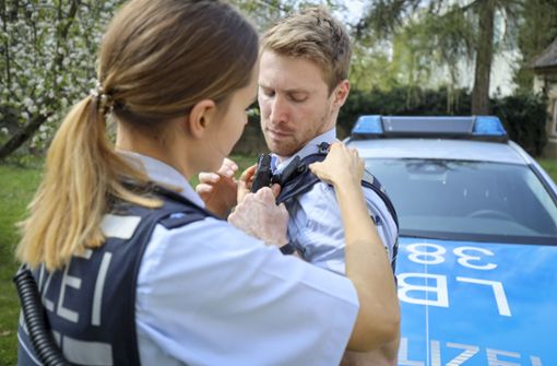 Die Streifenpolizistin Laura Geißler hilft ihrem Kollegen Nils Mayer, die kleine Kamera an der Schulter anzubringen. Foto: factum/Simon Granville
