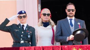 Kronprinzessin Mette-Marit (M), Kronprinz Haakon (r) und Prinzessin Ingrid Alexandra begrüßen den Kinderzug vom Schlossbalkon. Foto: Heiko Junge/NTB/dpa