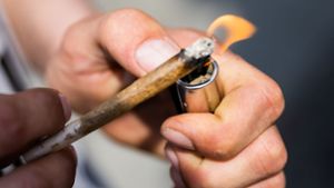 Ein Mann zündet einen Joint an:  Joint (auch Tüte genannt) ist ein mit Cannabisprodukten (meist Haschisch oder Marihuana) gefülltes Papier, das zusammengedreht wird, um es zu rauchen. Foto: dpa/Christoph Soeder