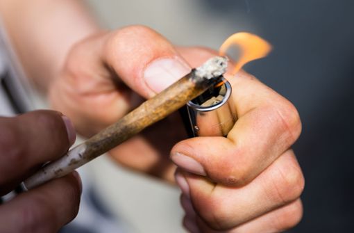 Ein Mann zündet einen Joint an:  Joint (auch Tüte genannt) ist ein mit Cannabisprodukten (meist Haschisch oder Marihuana) gefülltes Papier, das zusammengedreht wird, um es zu rauchen. Foto: dpa/Christoph Soeder