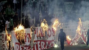 Die griechischen Fußball-Fanatiker sind berüchtigt: Vermummte Fans verbrennen während eines Athener Derbys ein Banner vor den Zuschauertribünen Foto: dpa