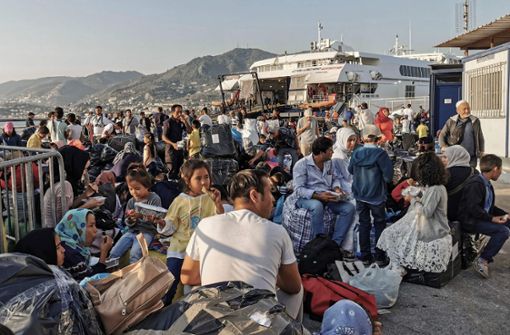 Flüchtlinge warten auf Lesbos, um an Bord eines Schiffes zu gehen – sie waren zuvor im Camp Moria untergebracht. Foto: AFP/STRINGER