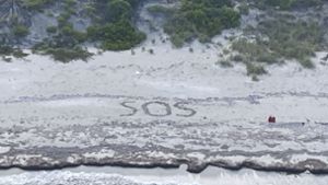 Der 64-Jährige schrieb „SOS“ in den Sand der Insel. Foto: dpa/Uncredited