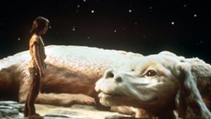 Noah Hathaway steht in seiner Rolle als Atreju in der Verfilmung von „Die unendliche Geschichte“ neben dem Glücksdrachen Fuchur (Szenenfoto von 1983). Foto: dpa