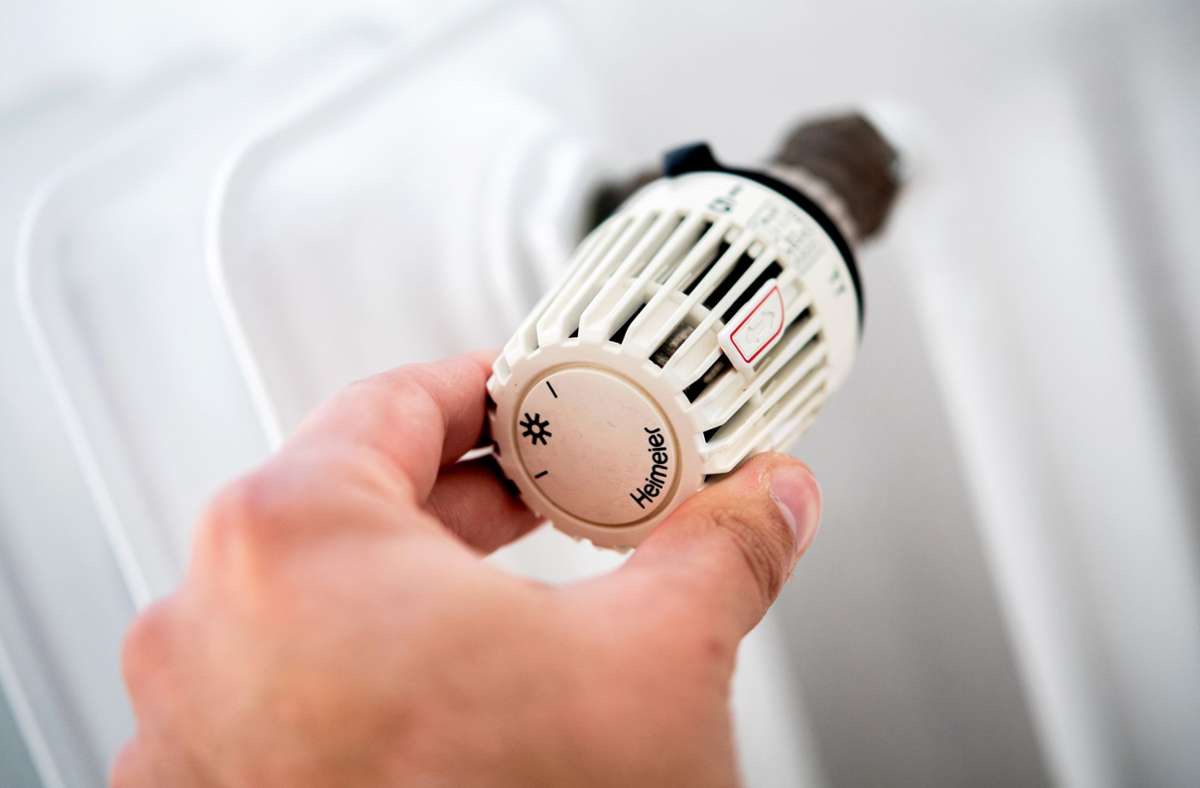 Ein Mann dreht in seiner Wohnung am Thermostat einer Heizung. Foto: dpa/Hauke-Christian Dittrich