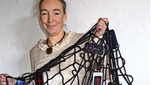 Marion Musch präsentiert ihre Netzinstallation, an der 36 Handys und Tablets hängen. Diese wird bei der Messe „Arte-Sono“ zu sehen sein. Foto: Fatma Tetik