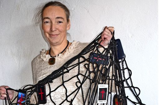 Marion Musch präsentiert ihre Netzinstallation, an der 36 Handys und Tablets hängen. Diese wird bei der Messe „Arte-Sono“ zu sehen sein. Foto: Fatma Tetik