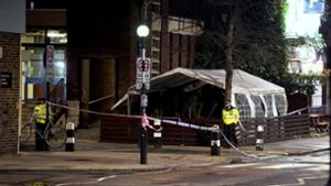 Polizisten stehen in der Nähe des Tatorts. Im Januar waren in der Nähe einer Kirche aus einem Auto heraus Schüsse auf Trauernde abgegeben worden. (Archivfoto). Foto: dpa/James Manning