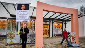 Ein Mann bringt mit einem Schild seinen Unmut über die aktuelle Politik vor dem Drogeriemarkt in Kandel (Rheinland-Pfalz) zum Ausdruck. In dem Laden wurde am Mittwoch ein junges Mädchen von ihrem afghanischen Ex-Freund erstochen. Foto: dpa