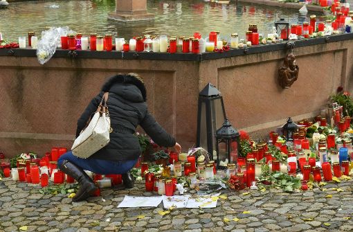 Eine Frau legt Blumen auf dem Marktplatz in Endingen für die getötete Joggerin nieder. Die 27 Jahre alte Frau war vergewaltigt und getötet worden. Foto: dpa