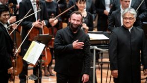 Kirill Petrenko (Mitte) neben dem Bass-Solisten Kwangchul Youn und Musikern der Berliner Philharmoniker nach seinem Antrittskonzert Foto: dpa