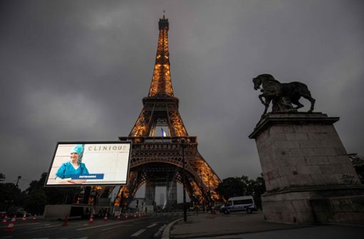 Am Abend erstrahlten die Gesichter einiger Franzosen und Französinnen vor dem Eiffelturm. Foto: AFP/Thomas Samson