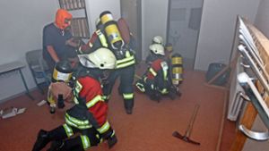 Beim simulierten Brandort wird ein Eingeschlossener gefunden: Die Hemminger Feuerwehr im Übungseinsatz im Keller der Gemeinschaftshalle. Foto: factum/Bach