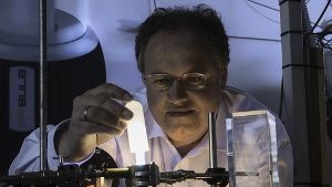 Mit einer Phosphorbeschichtung gelingt es Forscher Rainer Kling, die neu entwickelte Hochdrucklampe warm-weiß leuchten zu lassen. Foto: Martin Lober/KIT