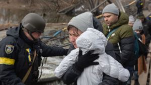 Ukraine, Irpin: Kriegsflüchtlinge werden von Soldaten während der Evakuierung über die gesprengte Brücke begleitet. Foto: dpa/Mykhaylo Palinchak