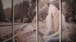 Ein Moment der Ruhe. Alena Bacher sitzt auf einer Schiene und hängt ihren Gedanken nach. Der Fotograf Jochem Hüskes nennt dieses Bild „Entdecken – Der Tramp“. Foto: Malte Klein