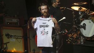 Jesse Hughes, Frontmann der Eagles of Death Metal, hält während des Konzerts in Paris ein T-Shirt in die Höhe, auf dem steht:  „I really wanna be in Paris“ Foto: AP