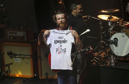 Jesse Hughes, Frontmann der Eagles of Death Metal, hält während des Konzerts in Paris ein T-Shirt in die Höhe, auf dem steht:  „I really wanna be in Paris“ Foto: AP