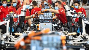 Porsche-Mitarbeiter in Stuttgart-Zuffenhausen tragen  in der Produktion des E-Autos Taycan Mundschutz. Foto: dpa/Marijan Murat