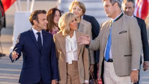 Frankreichs Staatspräsident Emmanuel Macron (l) und seine Frau Brigitte unterhalten sich nach der Ankunft am Flughafen München mit Markus Söder (r, CSU), Ministerpräsident von Bayern. Foto: dpa/Daniel Karmann
