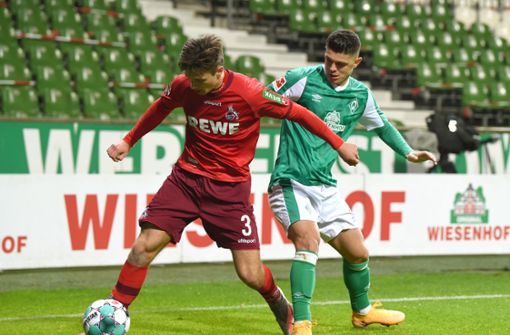 Kölns Noah Katterbach (l.) kämpft gegen Werders Milot Rashica um den Ball. Foto: dpa/Carmen Jaspersen